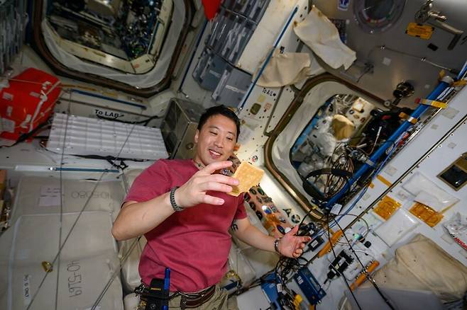 나사 우주비행사 조니 김이 국제우주정거장에서 고추장 버거를 먹고 있다. 조니 김 페이스북