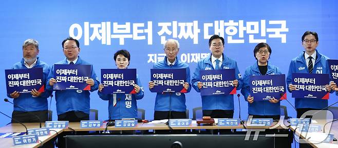 더불어민주당 박찬대, 윤여준 상임총괄선거대책위원장 등이 2일 오전 서울 여의도 중앙당사에서 열린 중앙선거대책위원회의에서 손피켓을 들고 기념촬영을 하고 있다. 2025.5.2/뉴스1 ⓒ News1 김민지 기자