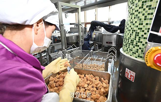 전국 최초로 급식 로봇을 시범 운영 중인 서울 성북구 숭곡중학교에서 2023년 11월 22일 조리사가 급식 로봇이 조리한 닭튀김의 온도를 확인하고 있다. 경향신문 자료사진