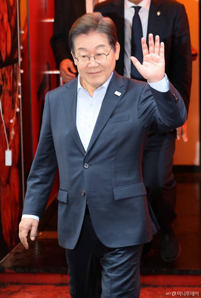 (서울=뉴스1) 이재명 기자 = 이재명 더불어민주당 대통령 후보가 1일 서울 종로구의 한 포차 식당에서 '당신의 하루를 만드는, 보이지 않는 영웅들'이란 주제로 열린 배달 라이더, 택배 기사 등 비(非)전형 노동자들과 간담회를 마친 뒤 나서며 손인사를 하고 있다. (공동취재) 2025.5.1/뉴스1 Copyright (C) 뉴스1. All rights reserved. 무단 전재 및 재배포, AI학습 이용 금지. /사진=(서울=뉴스1) 이재명 기자