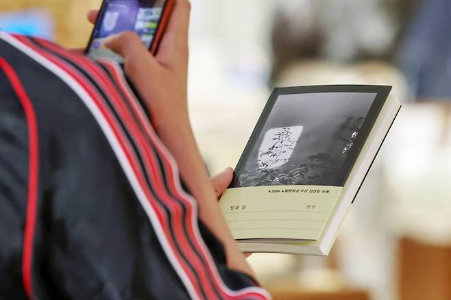 한국인 첫 노벨문학상을 수상한 작가 한강의 신작 에세이 '빛과 실'이 종합 베스트셀러 1위에 올랐다. 사진은 지난달 24일 서울 종로구 교보문고 광화문점에서 한 시민이 한강 작가의 신작 '빛과 실'을 스마트폰 카메라로 담고 있다. /사진=뉴스1