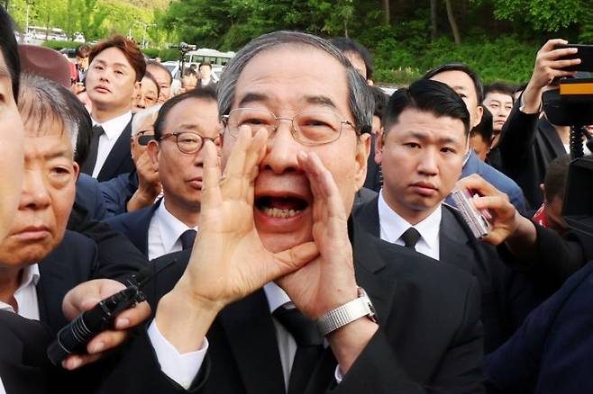 지난 2일 오후 광주 북구 국립 5·18민주묘지를 찾은 한덕수 전 총리가 광주비상행동 등 시민·사회단체 관계자들의 반발에 가로 막히자 "저도 호남 사람"이라며 참배를 호소하고 있다. 연합뉴스