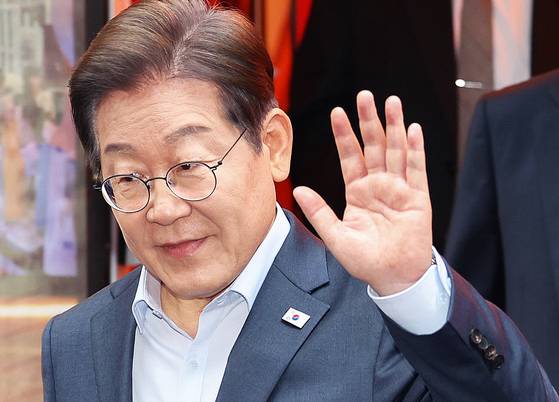 더불어민주당 이재명 대선 후보가 1일 서울 종로구의 한 포차 식당에서 '당신의 하루를 만드는, 보이지 않는 영웅들'이란 주제로 열린 배달 라이더, 택배 기사 등 비(非)전형 노동자들과의 간담회를 마친 뒤 나서며 손인사하고 있다. 연합뉴스