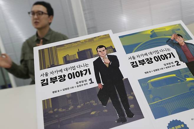 '서울 자가에 대기업 다니는 김 부장 이야기' 단행본 (서울=연합뉴스) 강민지 기자 = 송희구 작가가 지난 28일 서울 강남구 바로엔터테인먼트에서 연합뉴스와 인터뷰를 하고 있다. 사진은 작가의 웹소설을 원작으로 만들어진 웹툰 단행본. 2025.5.4
mjkang@yna.co.kr