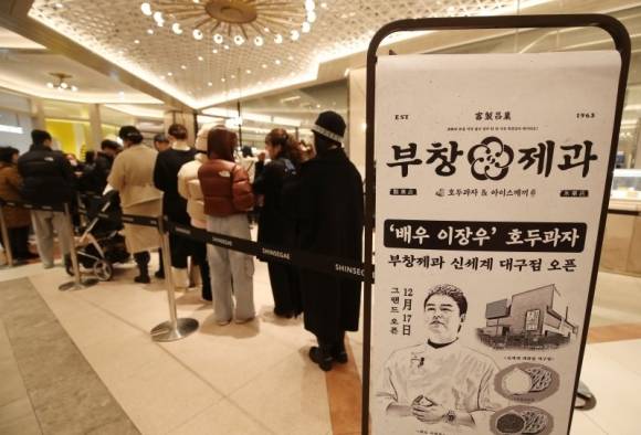 18일 대구 동구 신세계백화점 대구점에서 영업을 시작한 호두과자 브랜드 ‘부창제과 2호점’ 앞에 많은 시민들이 호두과자를 구입하기 위해 줄지어 차례를 기다리고 있다. 2024.12.18. 뉴스1