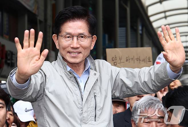 김문수 국민의힘 대통령 후보가 6일 경북 포항시 죽도시장에서 시민들을 향해 인사하고 있다. 뒷편에는 한 지지자가 '양보 하지 마세요'라고 적힌 종이를 들어보이고 있다. 2025.5.6/뉴스1 ⓒ News1 김민지 기자