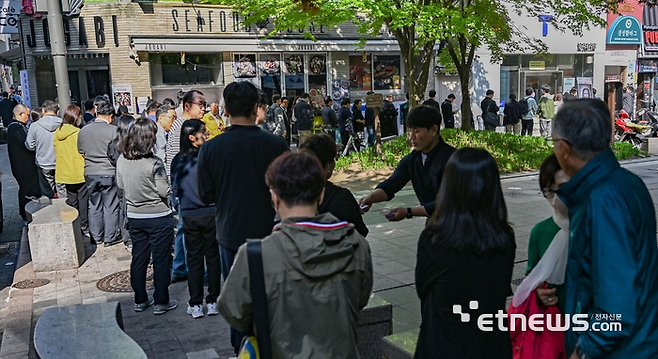 SK텔레콤이 유심 해킹 사고와 관련해 전국 T월드 매장에서 희망 고객을 대상으로 무료 유심 교체를 진행하는 가운데 교체 첫 날인 28일 서울 중구 SKT PS&M 을지로점 앞에서 관계자가 이용자들에게 번호표를 나눠주고 있다. 이동근 foto@etnews.com