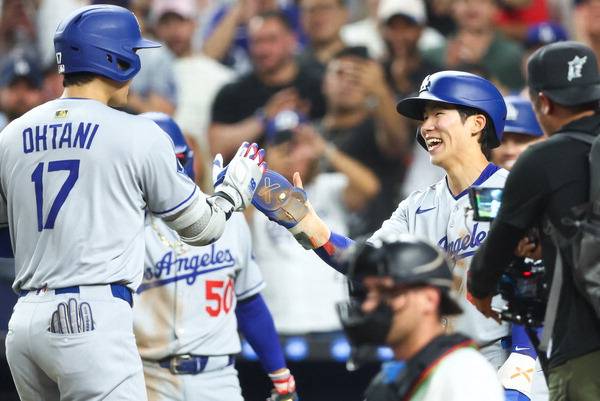 로스앤젤레스 다저스 김혜성(오른쪽)이 6일(한국시간) 미국 마이애미 론디포 파크에서 열린 MLB 마이애미 말린스와의 경기에서 5회 빅리그 첫 안타를 치고 출루해 오타니의 홈런으로 홈을 밟은 뒤 하이파이브를 하고 있다. AFP 연합뉴스