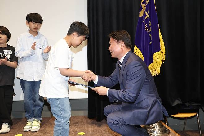 조용익 경기 부천시장이 1일 부천시청에서 열린 ‘2025년 제103회 어린이날 기념식’에서 심폐소생술로 어머니를 살린 정태운군에게 모범어린이 표창장을 수여하고 있다. 부천시 제공