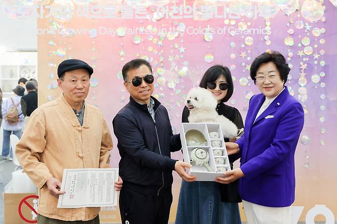 올해 이천도자기축제 100만 번째 관람객으로 당첨된 별이네 가족이 김경희 시장(오른쪽)에게 다기세트를 선물받고 있다. 이천시 제공