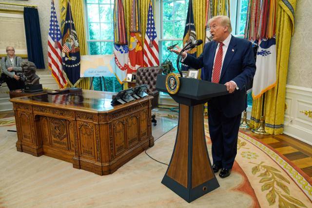 도널드 트럼프(오른쪽) 미국 대통령이 7일 워싱턴 백악관 집무실(오벌오피스)에서 데이비드 퍼듀 주중 대사 선서식이 끝난 뒤 취재진 질문을 받고 있다. 워싱턴=AP 연합뉴스