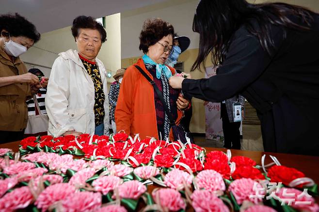 어버이날인 8일 서울 송파노인종합복지관에서 열린 '꽃처럼 찬란한 어르신, 감사해효(孝) 행사'에 참가한 어르신이들이 가슴에 카네이션을 달고 있다. 박종민 기자