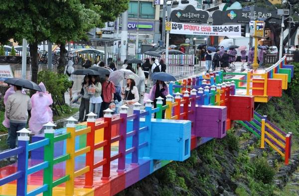 제주도에 호우특보가 내려진 9일 오전 제주시 산지천 인근에서 수학여행 온 학생들이 우산을 쓰고 이동하고 있다. 연합뉴스