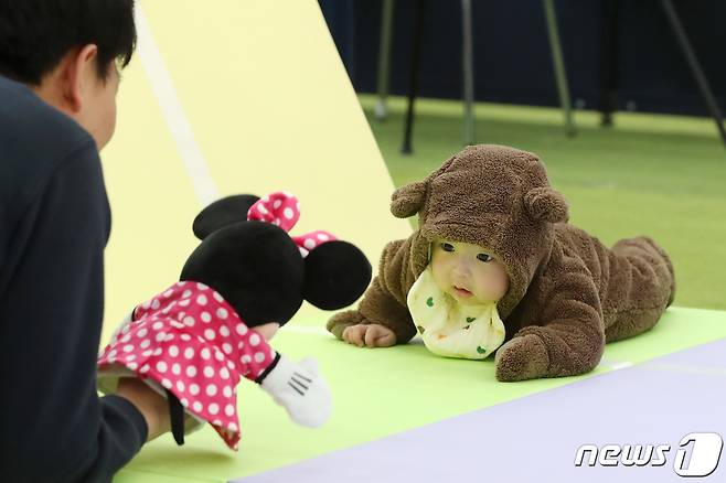 대구 북구 엑스코에서 개막한 '제39회 대구베이비&키즈페어(대구베키)'의 부대행사로 열린 생후 12개월 이하 아기들의 경주 '컴 온 베이비(come on baby)' 이벤트에 출전한 아기들이 아빠·엄마의 손짓을 바라보며 결승선을 향해 다가가고 있다. 2024.3.7/뉴스1 ⓒ News1 공정식 기자