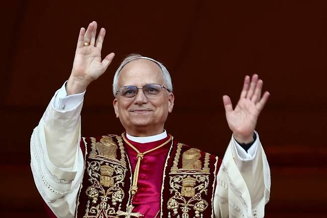 새 교황으로 선출된 미국 로버트 프레보스트 추기경이 8일(현지시간) 성 베드로 대성전 '강복의 발코니'로 나와 군중들을 향해 손을 흔들고 있다. 로이터/연합뉴스 제공