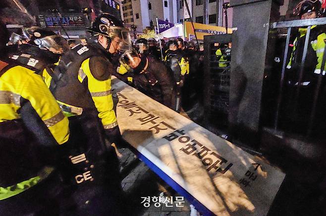 경찰이 지난 1월19일 서울 마포구 서울서부지법 후문에서 윤석열 전 대통령의 구속에 항의하며 시위대가 넘어뜨린 법원 간판을 다시 세우고 있다. 이준헌 기자
