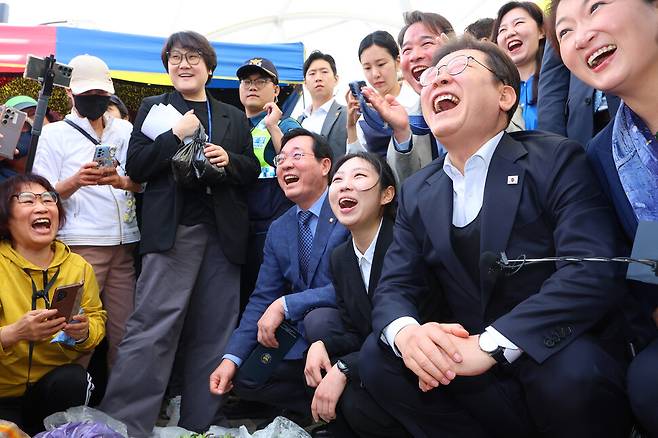 이재명 민주당 대통령 후보가 5월 10일 경남 함안군 가야전통시장에서 상인들과 이야기하며 밝게 웃고 있다. 연합뉴스