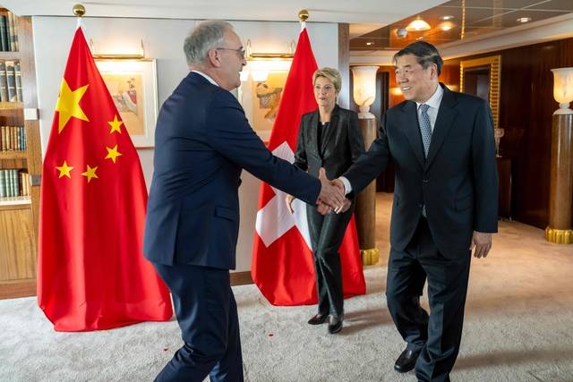 9일(현지시간) 스위스 제네바에서 기 빠믈렝 (왼쪽)스위스 경제연구교육부 장관과 허리펑 중국 부총리가 악수를 나누고 있다. 카린 켈러-수터 스위스 대통령은 이를 지켜보고 있다. AFP 연합뉴스