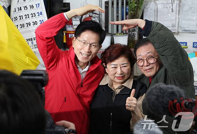 김문수 국민의힘 대선 후보가 제21대 대통령 선거 공식 선거운동이 시작된 12일 새벽 서울 송파구 양재대로 가락시장에서 상인들과 하트를 그리고 있다. 2025.5.12/뉴스1 ⓒ News1 이동해 기자