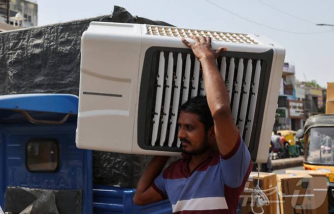 지난해 5월 인도 전역이 찜통 더위를 겪고 있는 가운데 서부 구자라트주(州)의 도시 아마다바드에서 노동자가 냉방기구를 운반하는 모습. 2024.05.30. ⓒ 로이터=뉴스1 ⓒ News1 김성식 기자