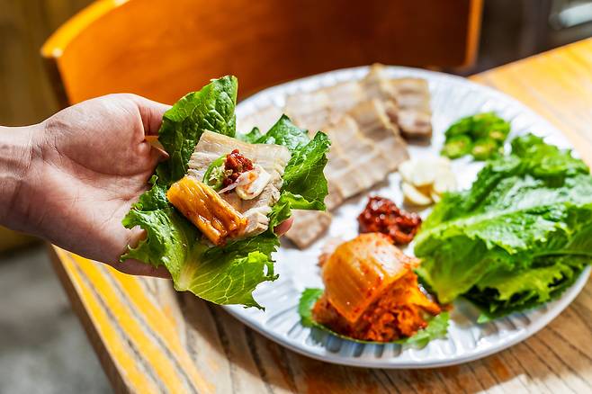 서울 강남구 ‘산호’의 돼지보쌈. 자기 접시에 부채꼴로 곱게 펼쳐서 나온 수육은 상앗빛을 반짝이며 윤이 났다. 껍질을 붙여 삶은 수육은 형태가 으그러지거나 삶은 지 오래되어 마른 부분이 없었다. /양수열 영상미디어 기자