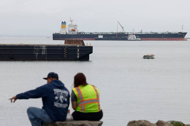 지난 6일(현지 시각) 미국 캘리포니아주 로스앤젤레스(LA) 항구에서 사람들이 인근에 정박한 화물선들을 바라보고 있다. / EPA=연합뉴스