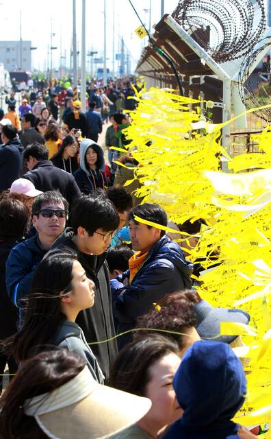 세월호가 목포신항에 입항한 가운데 2017년 4월2일 목포신항을 찾은 추모객들이 노란리본 등을 달며 희생자들의 넋을 위로하고 있다. 사진공동취재단