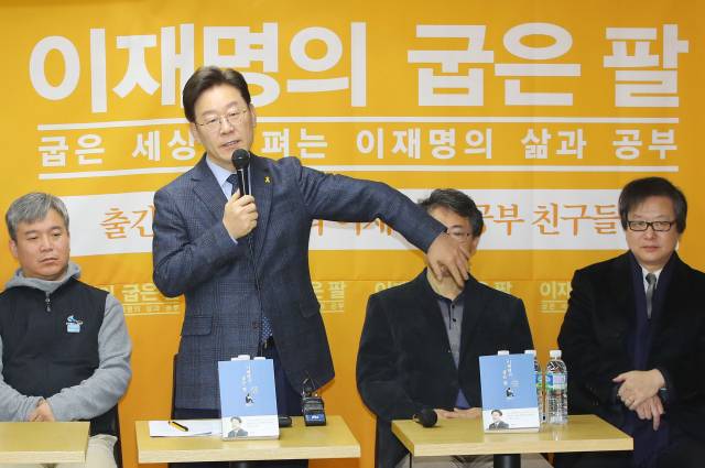 2017년 8월 '이재명의 굽은 팔' 출판 간담회에서 출간 소감을 밝히던 중 소년공 시절 사고로 굽은 왼쪽 팔을 들어보이고 있는 모습. 사진제공=더불어민주당