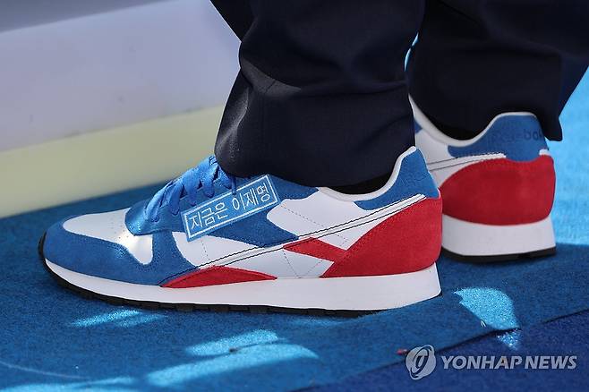 운동화에 붙은 "지금은 이재명" (서울=연합뉴스) 김주성 기자 = 더불어민주당 이재명 대선 후보가 6·3 대통령선거 공식 선거운동 첫날인 12일 서울 광화문 청계광장에서 열린 중앙선대위 출정식 및 첫 유세에서 "지금은 이재명"이라는 문구가 붙은 운동화를 신고 있다. 2025.5.12 utzza@yna.co.kr