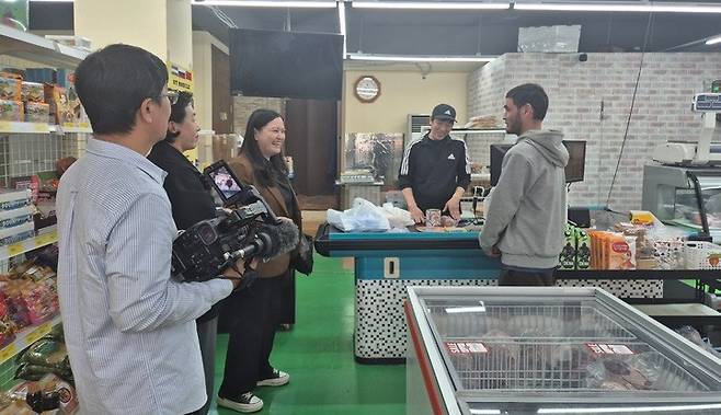 울산 동구 중앙아시아 식품점 '미야스노이 구르만(Мясной Гурман)'를 취재하고 있는 쿠세이노바 디나라(가운데).