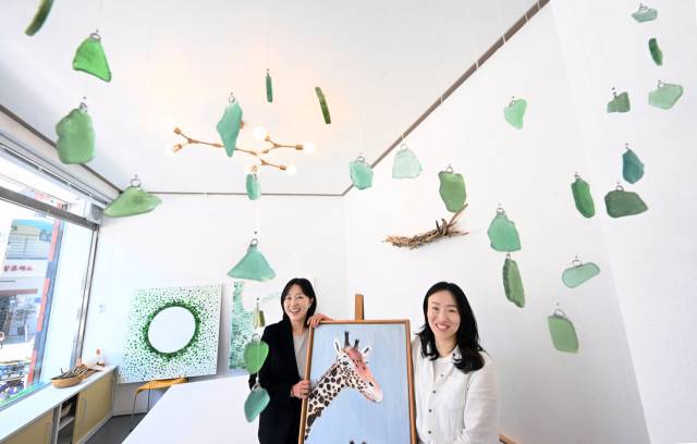 버금상점 김목연(오른쪽) 대표와 서인애 이사가 씨글라스 작품 앞에서 환하게 웃고 있다.