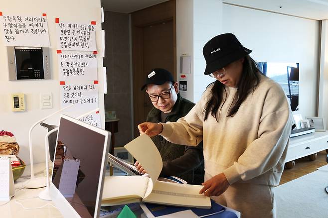 2025년 4월30일 경기도 용인시 집에 있는 송지은씨(오른쪽) 부부의 모습. 두 사람이 작업물을 함께 보고 있다. 류우종 기자
