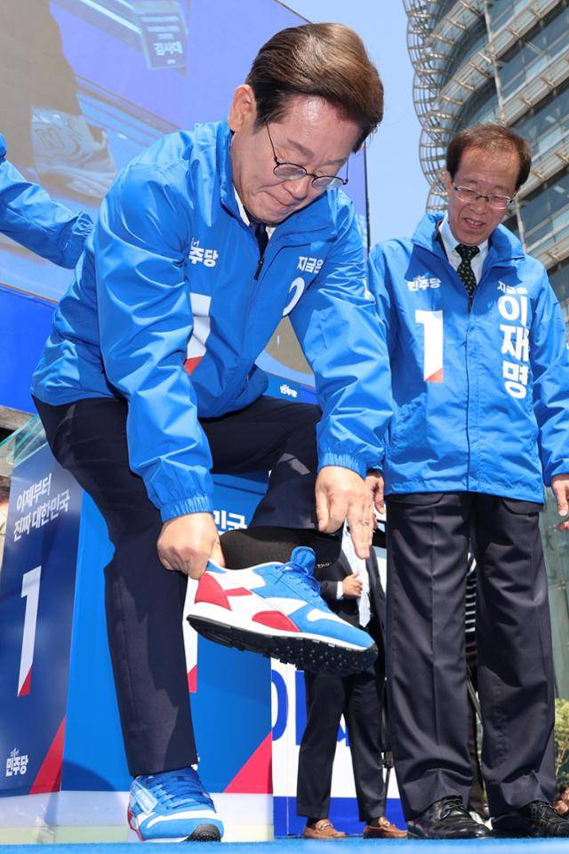 이재명 더불어민주당 대선 후보가 제21대 대통령선거 공식 선거운동이 시작된 12일 서울 청계광장에서 열린 중앙선거대책위원회 출정식 및 첫 유세에서 운동화를 신고 있다. 공동취재 사진