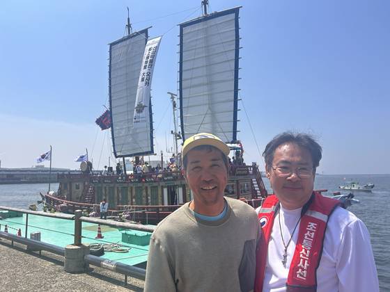 13일 일본 오사카항 ATC 부두에서 나란히 포즈를 취한 국립해양연구소의 홍순재(오른쪽) 학예연구사와 세토 내해 전통항해협회의 하라 고지 회장. 뒤에 보이는 조선통신사선 재현선이 세토 내해를 통과하는 과정에 하라 회장의 도움이 결정적이었다고 홍 학예사가 밝혔다. 오사카=강혜란 기자