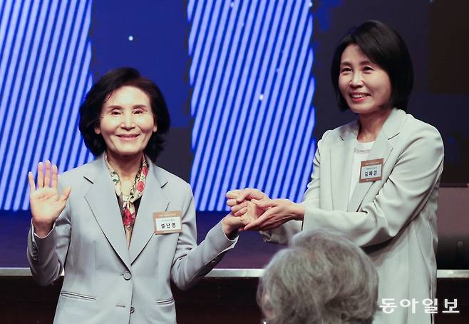 더불어민주당 이재명 대선 후보의 부인 김혜경 씨(오른쪽)와 국민의힘 김문수 후보의 부인 설난영 씨가 12일 서울 중구 장충동 신라호텔에서 열린 대한불교조계종 중앙신도회 창립 70주년 기념식에 참석해 손을 잡고 있다. 박형기 기자 oneshot@donga.com