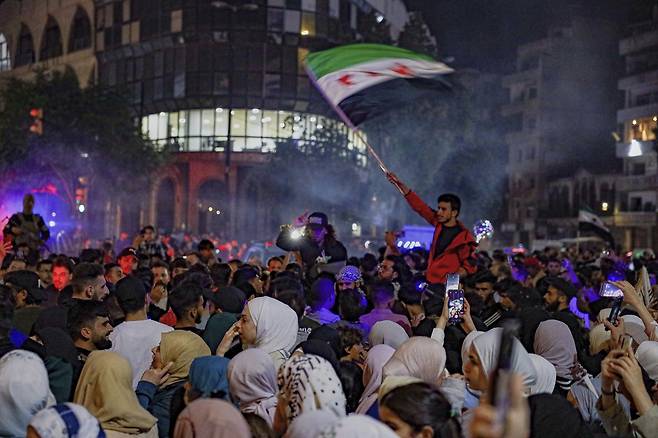 도널드 트럼프 미국 대통령이 시리아와 관계를 정상화하겠다고 밝힌 14일 시리아 홈스에서 시리아 국민들이 모여 축하하고 있다. AP연합뉴스