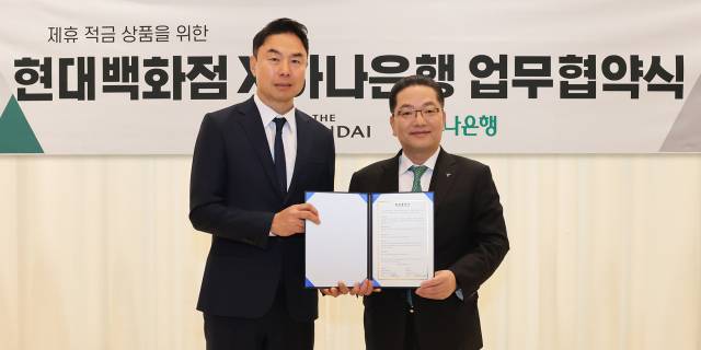 정지영(왼쪽) 현대백화점 사장과 이호성 하나은행장이 14일 서울 강남구 현대백화점 본사에서 제휴 적금 상품 출시를 위한 업무협약을 체결한 뒤 협약서를 들어보이고 있다. 사진 제공=현대백화점