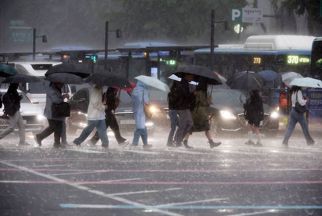 비가 내린 16일 서울 광화문사거리에서 시민들이 우산을 쓴 채 이동하고 있다. /연합뉴스