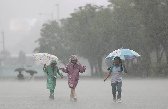 갑자지 폭우가 내린 16일 오후 서울 종로구 광화문 광장에서 아이들이 비를 피하기 위해 걸음을 재촉하고 있다. /장경식 기자