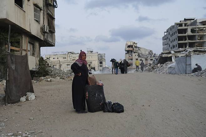 2025년 5월14일 이스라엘군의 대피 명령이 내려진 팔레스타인 땅 가자지구 북부 가자시티의 리말 지역에서 짐을 꾸린 여성 주민이 피란길에 오르고 있다. AP 연합뉴스