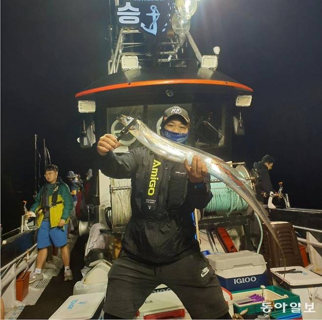 제주에서 선상 낚시를 즐기는 김민재 남녕고 코치가 잡은 갈치를 들어보이고 있다. 김민재 제공