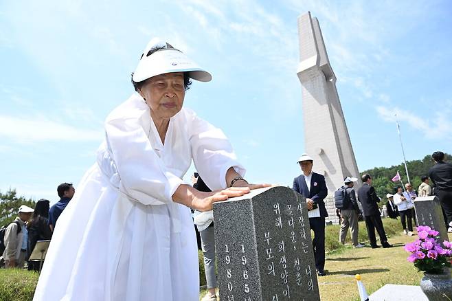18일 오전 광주 북구 5·18 민주묘지에서 제45주년 5·18 민주화운동 기념식을 마친 유족이 묘비를 어루만지고 있다. 공동취재 사진