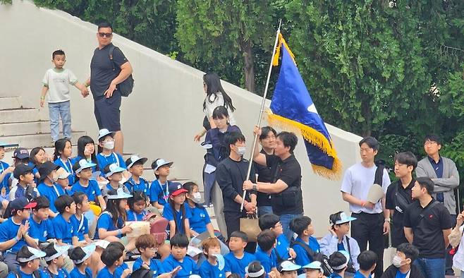 17일 열린 ‘2025학년도 대구경북본부 합동 선서식’에서 한 교사가 단가에 맞춰 학교 깃발을 흔들며 입장하고 있다. 한국과학우주청소년단 제공
