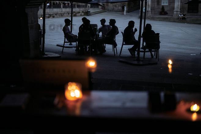 4월28일 스페인 전역에서 대정전 사태가 발생하자 북서 지방 도시 갈리시아의 한 레스토랑엔 촛불들이 켜져 있고 어두운 바깥에 사람들이 앉아 있다. ⓒEPA 연합