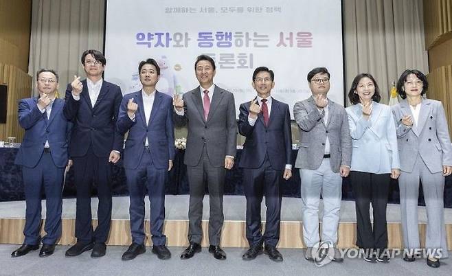 오세훈 서울시장과 김문수 국민의힘 대선후보, 이준석 개혁신당 대선후보를 비롯한 내빈들이 19일 서울 중구 서울시청에서 열린 '약자와 동행하는 서울 토론회'에 참석해 기념 촬영하고 있다. 연합뉴스