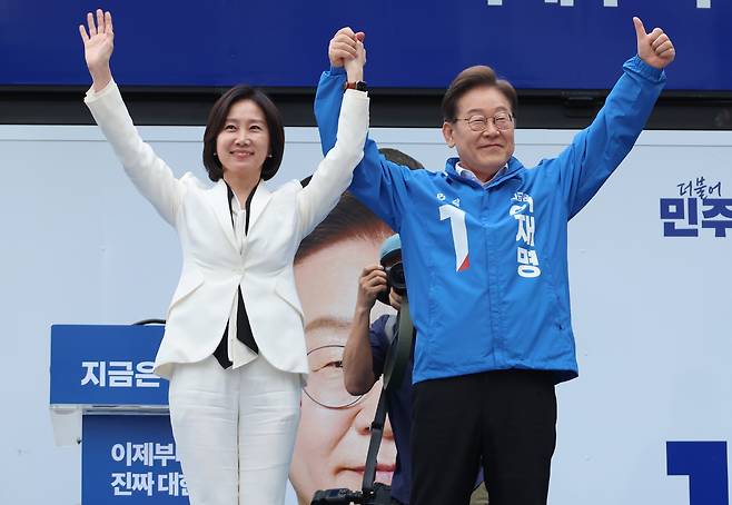 더불어민주당 이재명 대선 후보가 19일 서울 영등포구 타임스퀘어에서 열린 유세에서 허은아 전 개혁신당 대표와 함께 손을 잡고 포즈를 취하고 있다. 연합뉴스
