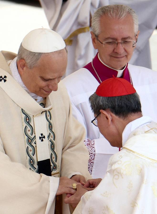 미국 출신 교황으로 취임한 레오 14세가 바티칸 성베드로 광장에서 열린 즉위 미사를 통해 제267대 교황으로 공식 취임했다. 사진은 지난 18일(현지시각) 루이스 타글 추기경이 바티칸 성 베드로 광장에서 열린 첫 미사에서 교황 레오 14세의 손가락에 어부의 반지를 끼워주는 모습. /사진=로이터