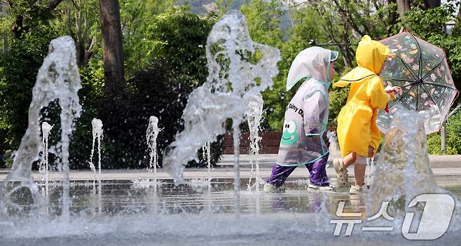 전국 대부분 지역 낮 기온이 25도 이상으로 올라 초여름 날씨를 보인 20일 서울 종로구 광화문광장 바닥분수에서 우의를 입은 어린이들이 물놀이를 하며 더위를 식히고 있다. 2025.5.20/뉴스1 ⓒ News1 이동해 기자