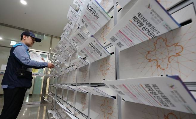 19일 서울 강남구 한 오피스텔에서 우체국 집배원이 제21대 대통령선거 책자형 선거공보물을 우편함에 넣고 있다. 연합뉴스