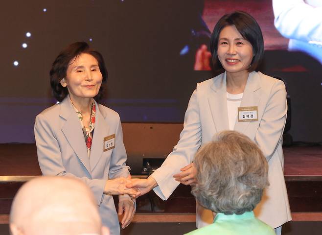 지난 12일 김문수 국민의힘 대선 후보의 부인 설난영 여사와 이재명 더불어민주당 대선 후보의 부인 김혜경 여사가 서울 중구 신라호텔에서 열린 중앙신도회 창립 70주년 기념식에서 손을 맞잡고 있다. 연합뉴스